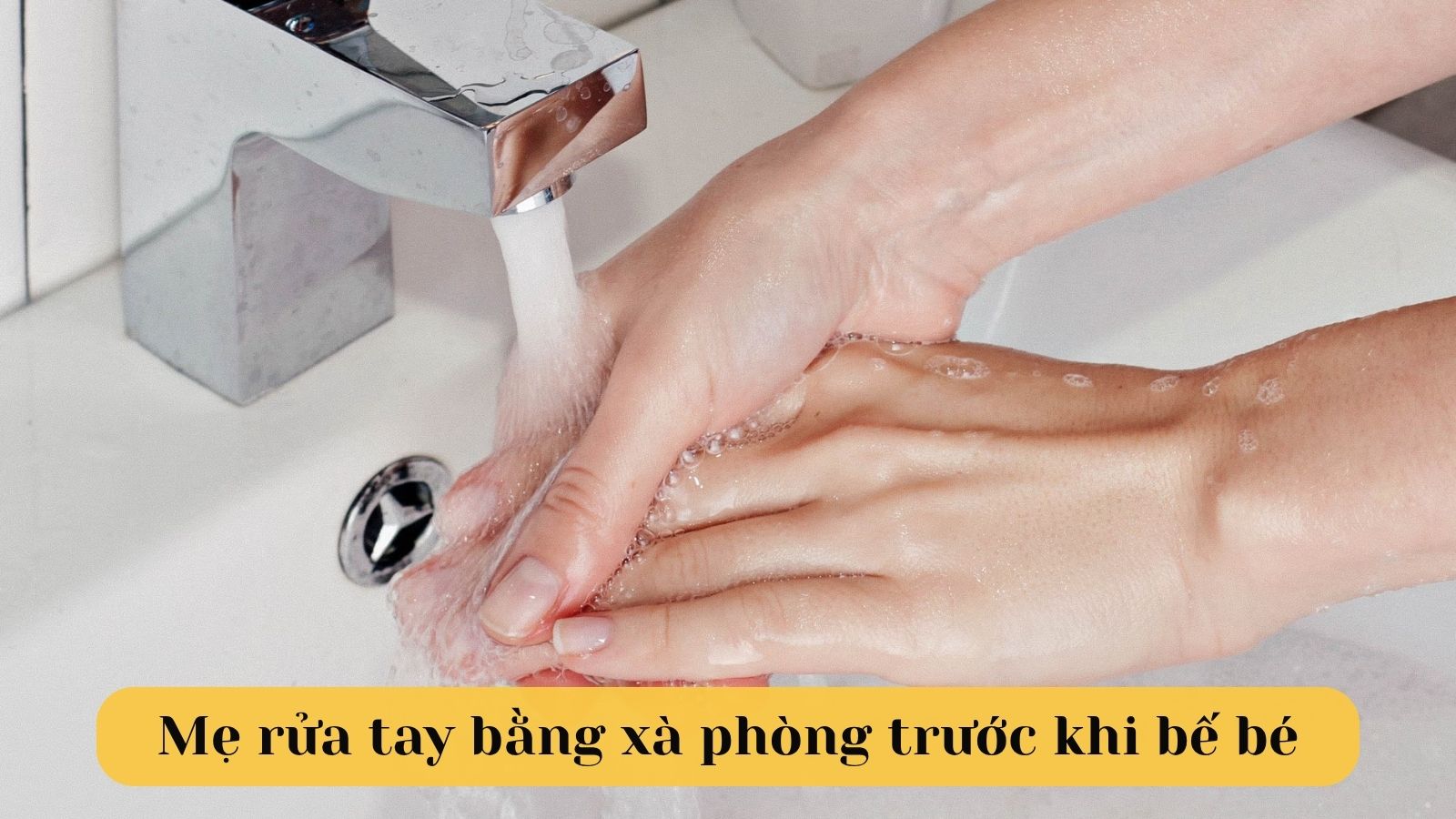 Mẹ rửa tay bằng x&agrave; ph&ograve;ng trước khi bế con